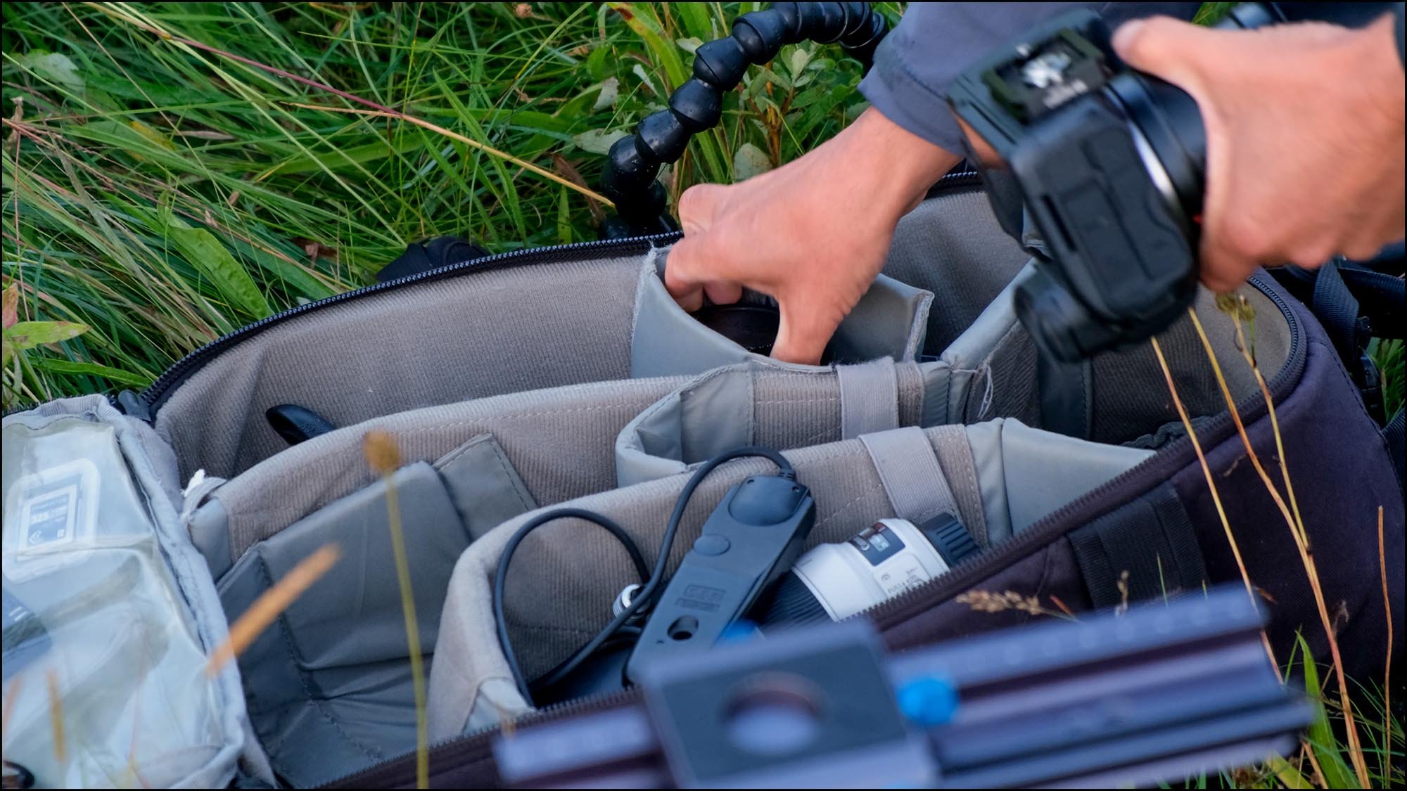 Hand getting macro photography equipment from camera bag