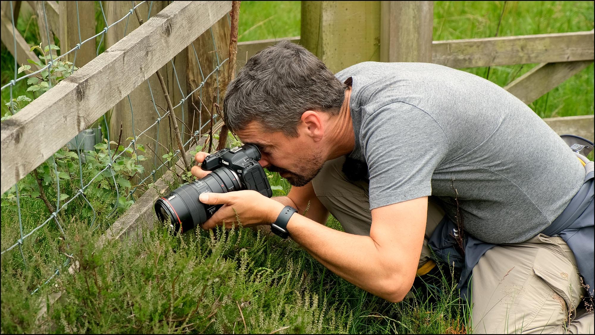 Photographer taking macro pictures in grass