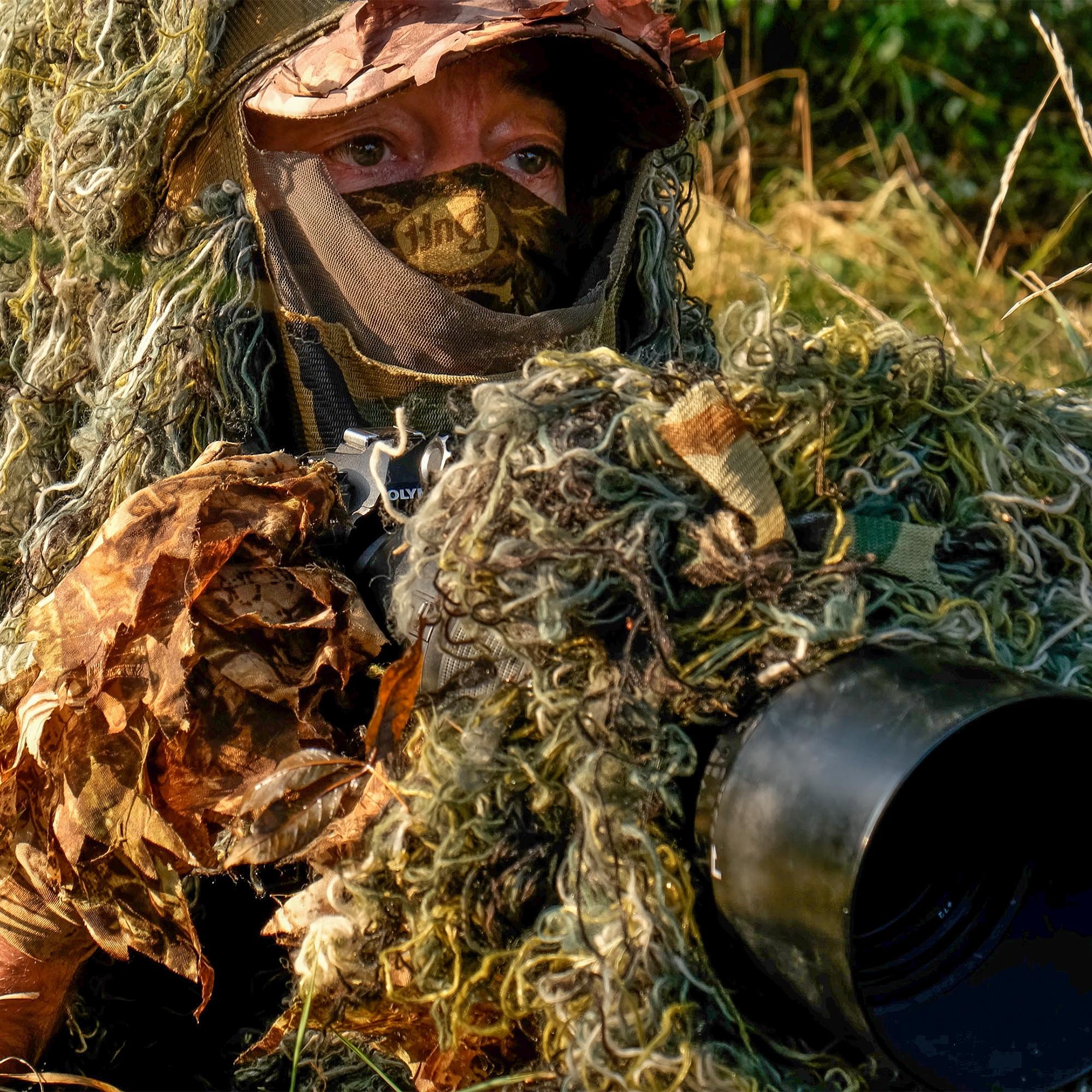 Wildlife photographer in camouflage with camera