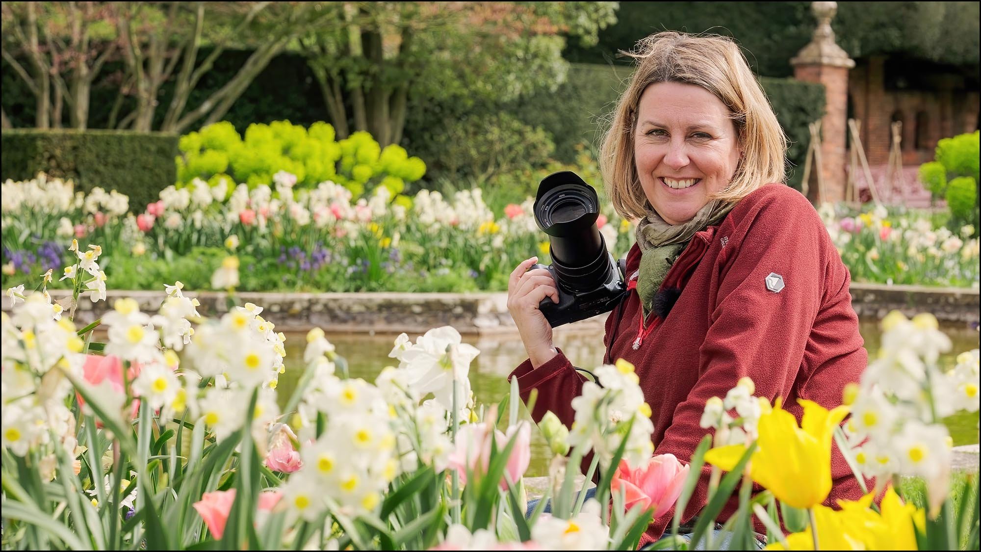 Flower photography course instructor Molly Hollman introducing the course in a spring garden surrounded by tulips and daffodils