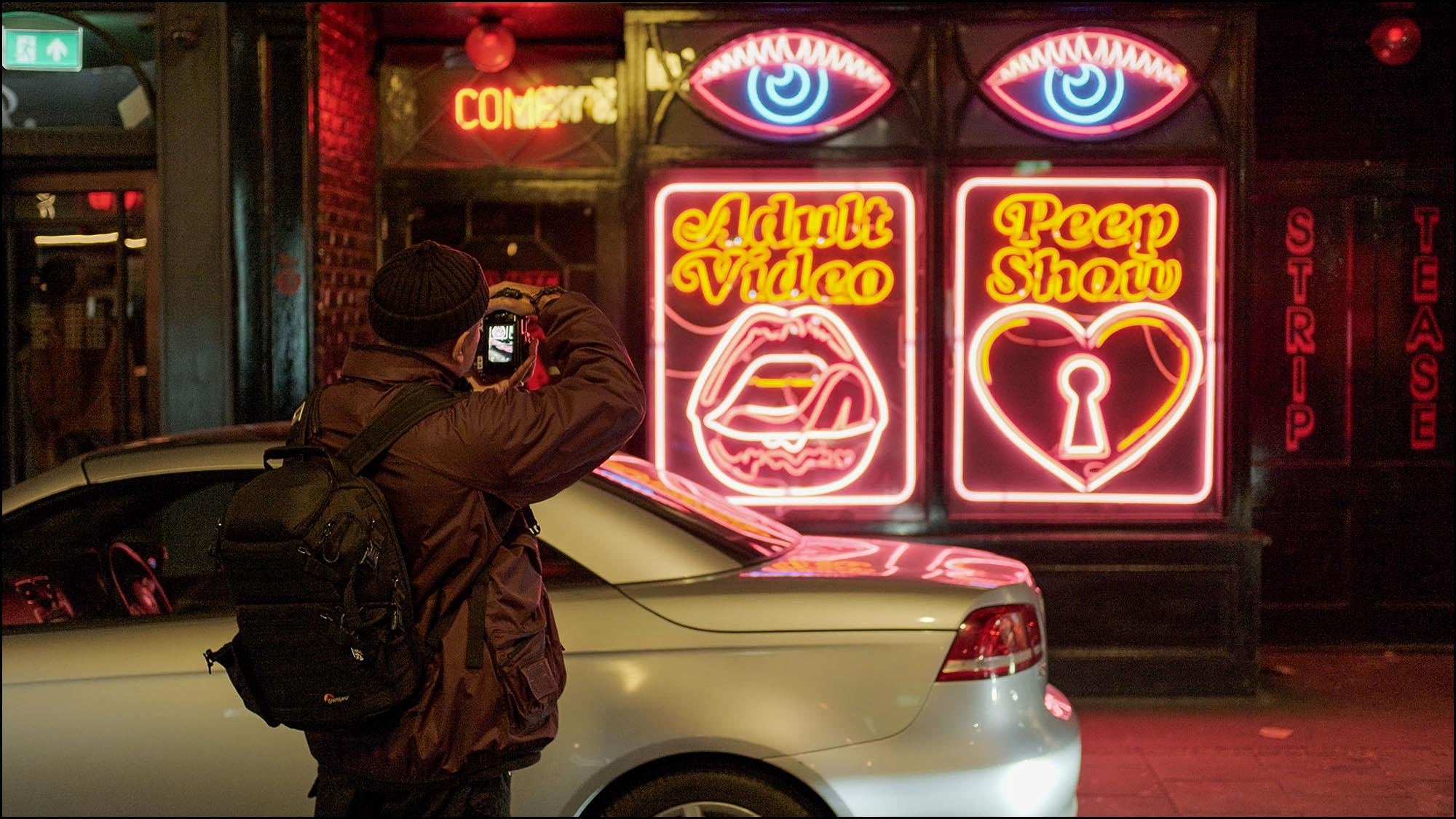 Bal on the street at night taking images of neon lights