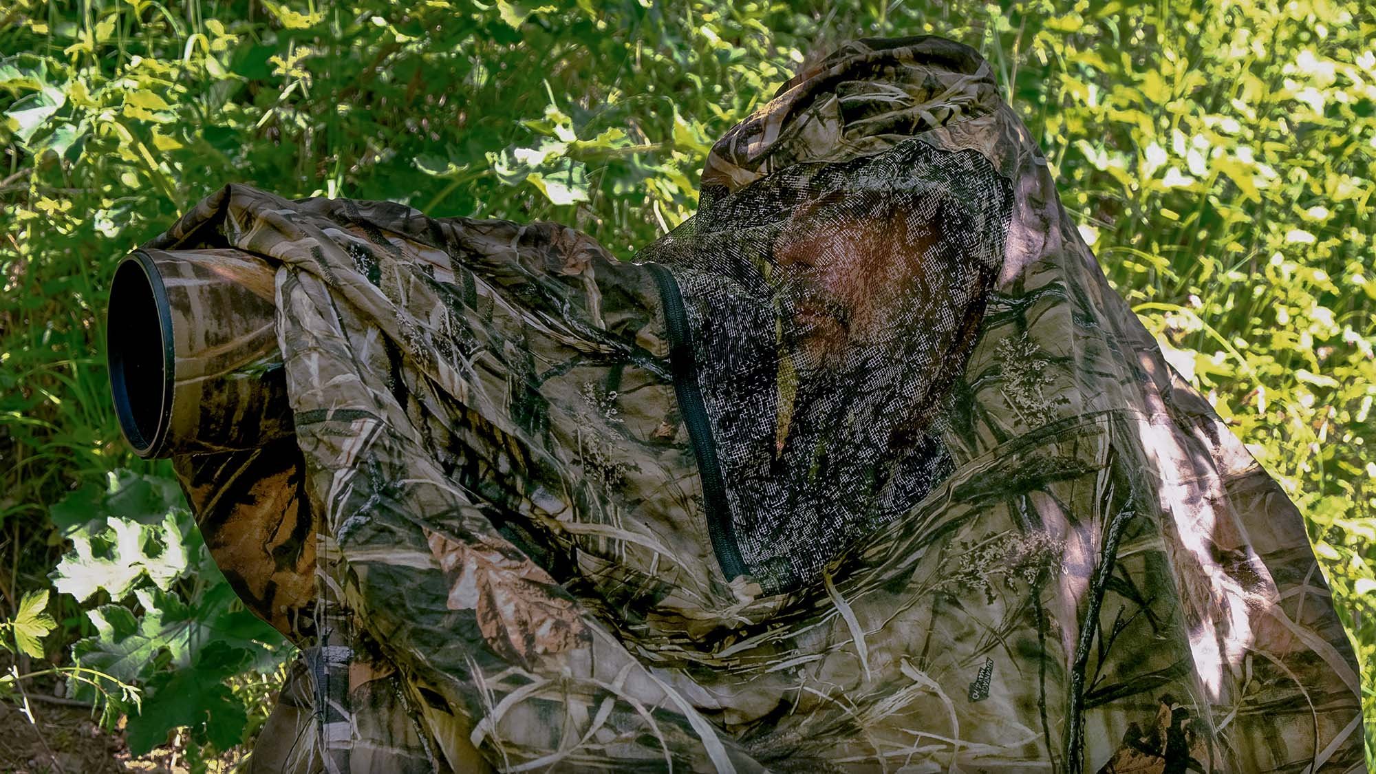 Photographer in a camoflagued bag hide