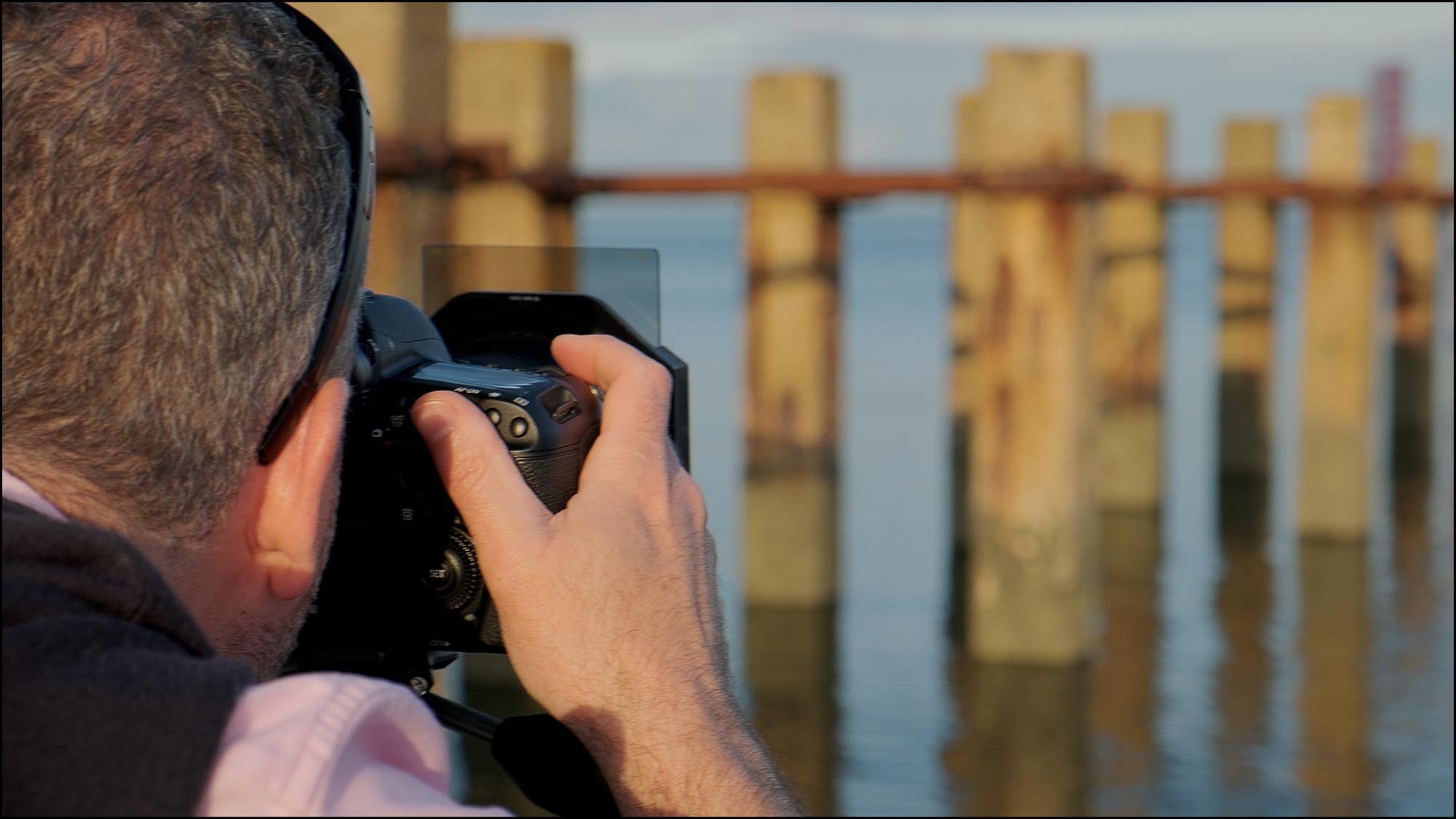Photographer taking long exposure picture of the sea