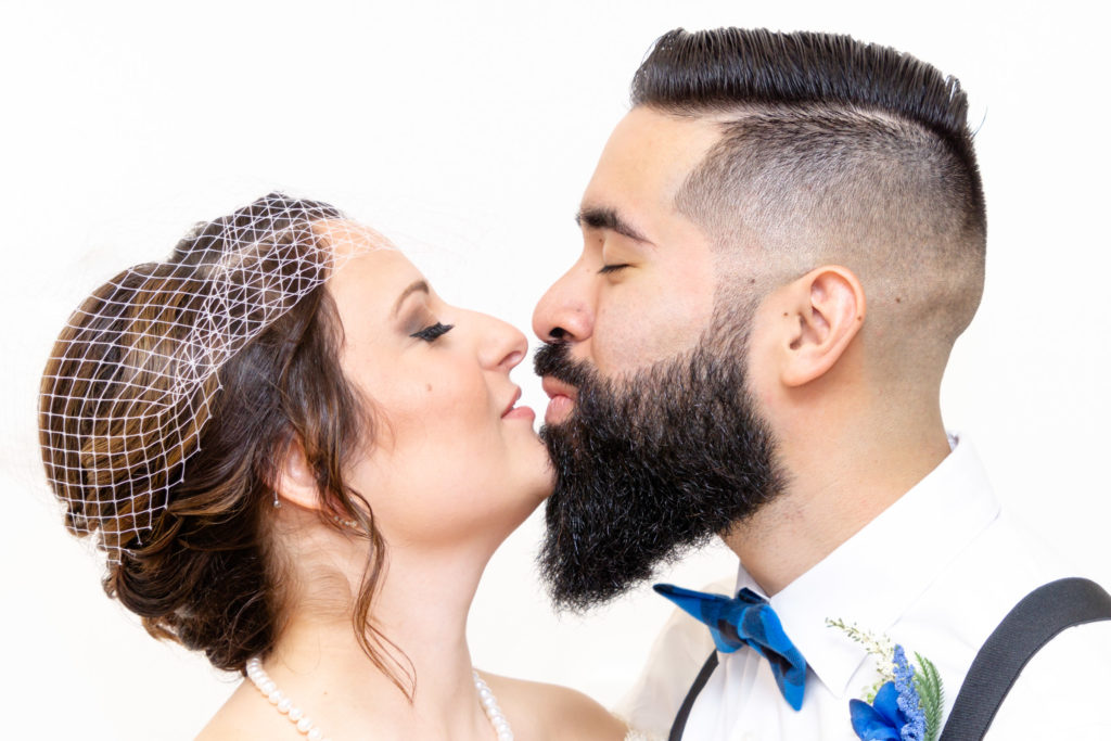 Head shot of bride & groom almost kissing.