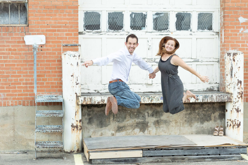 Caucasian husband and wife jumping.