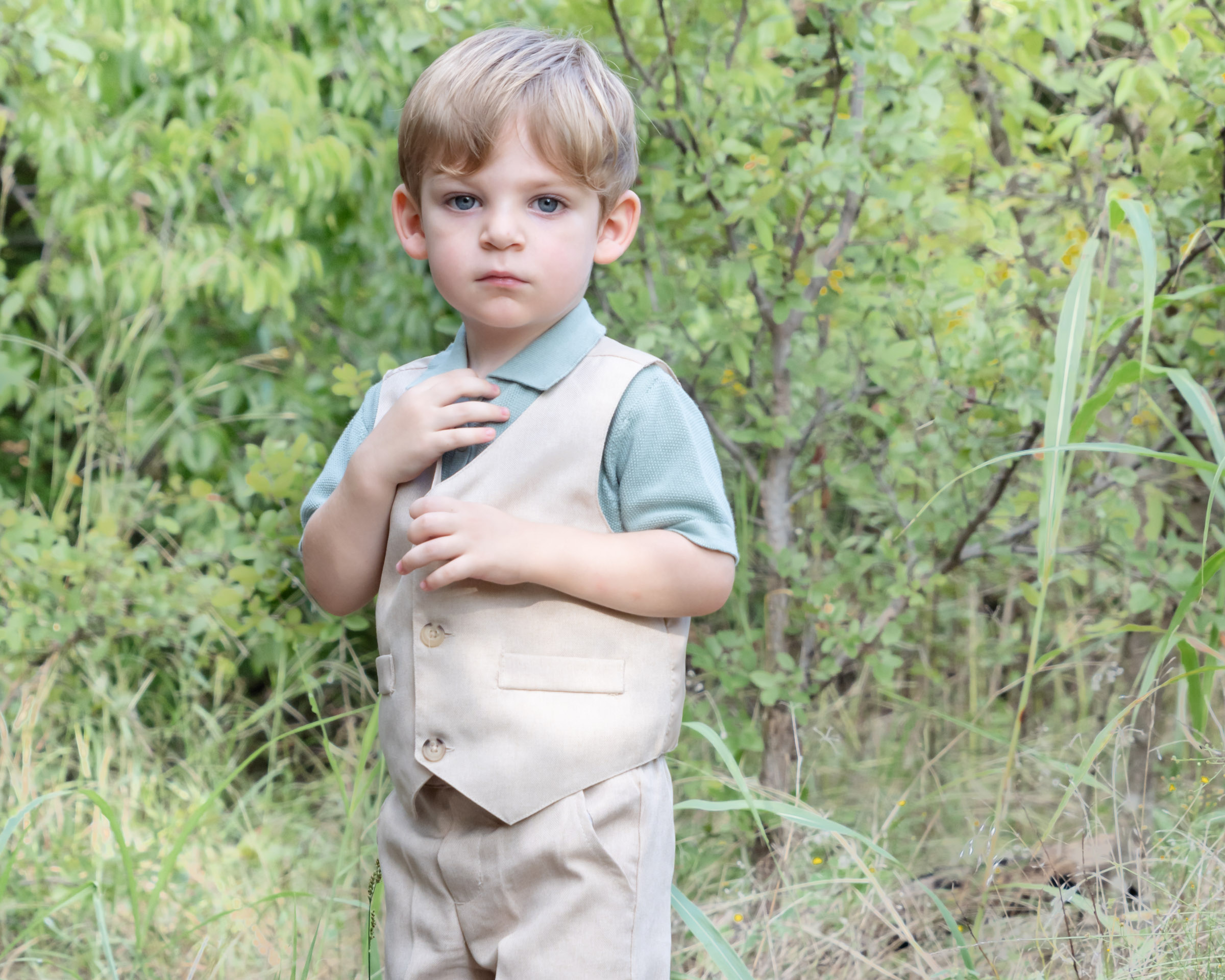 boy in khaki vest in front of trees. What to wear for kids